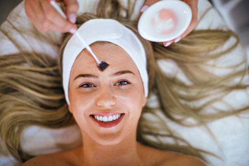 Woman receiving facial treatment with a smile